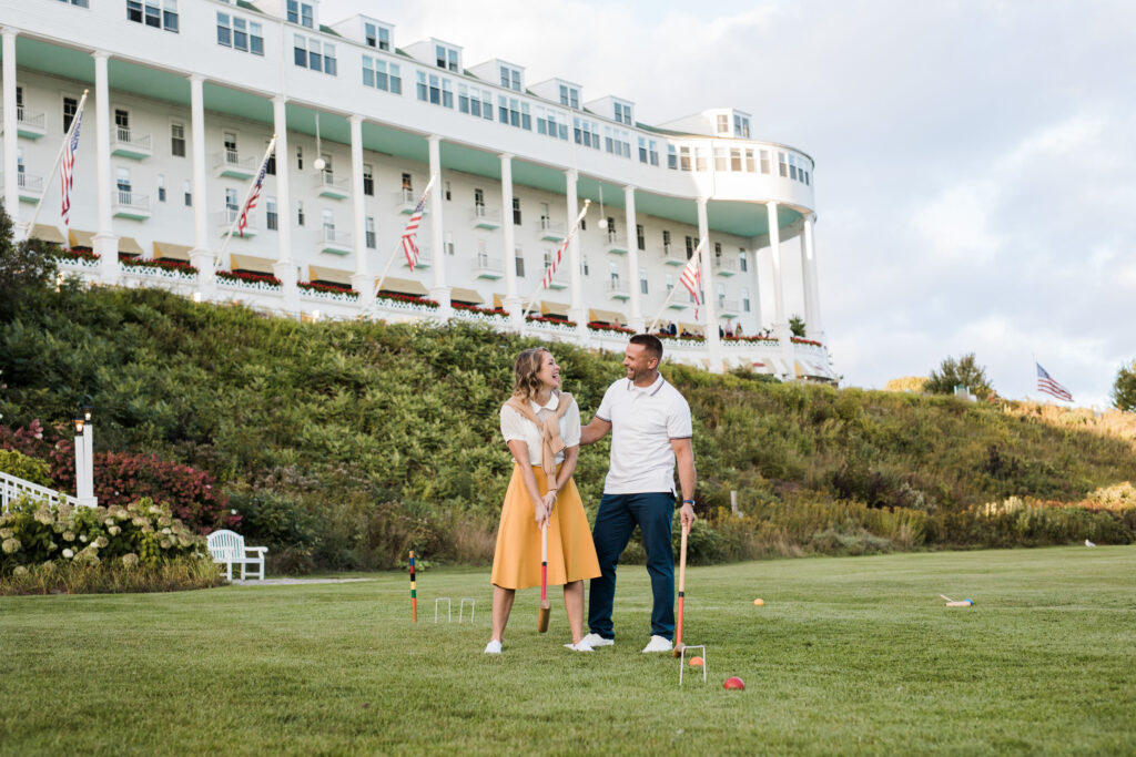 photo of a young playing croquet on a lawn in front of an upscale hotel - The Grand Hotel Hospitality Marketing