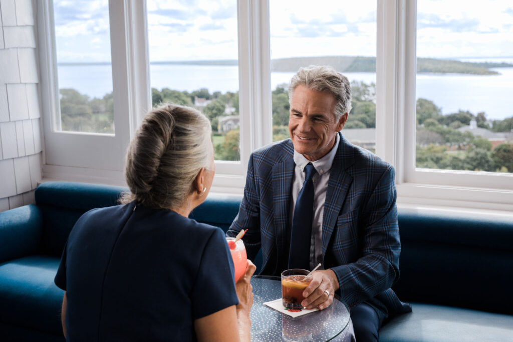 An older couple enjoying cocktails at a upscale bar - The Grand Hotel Hospitality Marketing