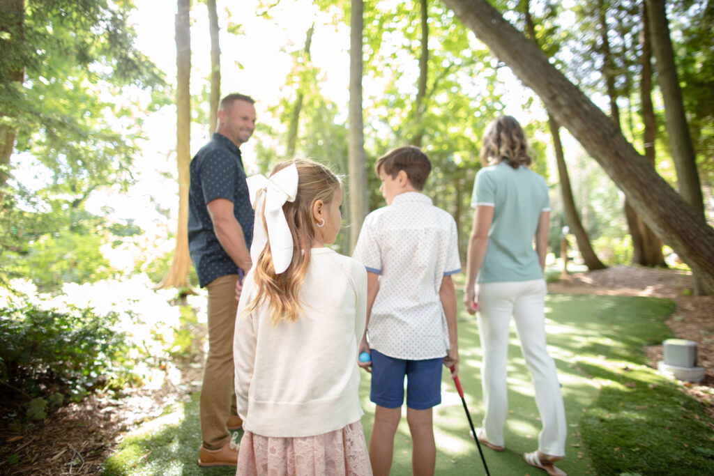 A family of four at putt-putt at a resort hotel - The Grand Hotel Hospitality Marketing