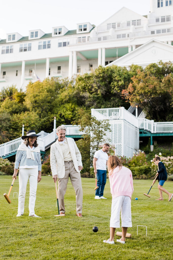 A family playing croquet on the lawn of a hotel - The Grand Hotel Hospitality Marketing