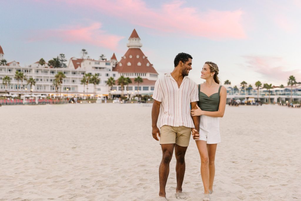 A young couple walking on a beach at dusk - Hotel Photography - Shore House at the Del