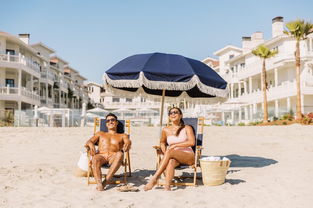 A young couple enjoying the sun on a beach - Hotel Photography - Shore House at the Del