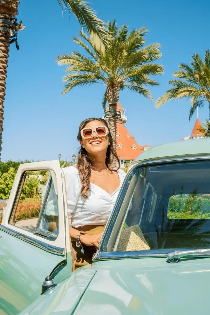 Young woman getting int o a vintage car with sun glasses - Hotel Photography - Shore House at the Del